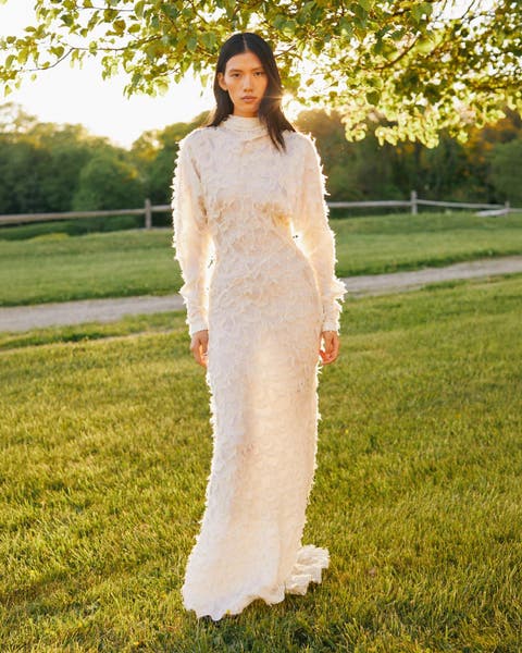 A woman wearing a long white lace gown.