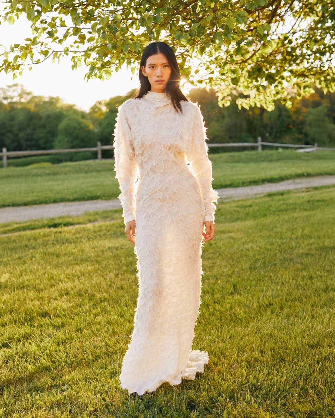 Woman in full-length white lace dress.