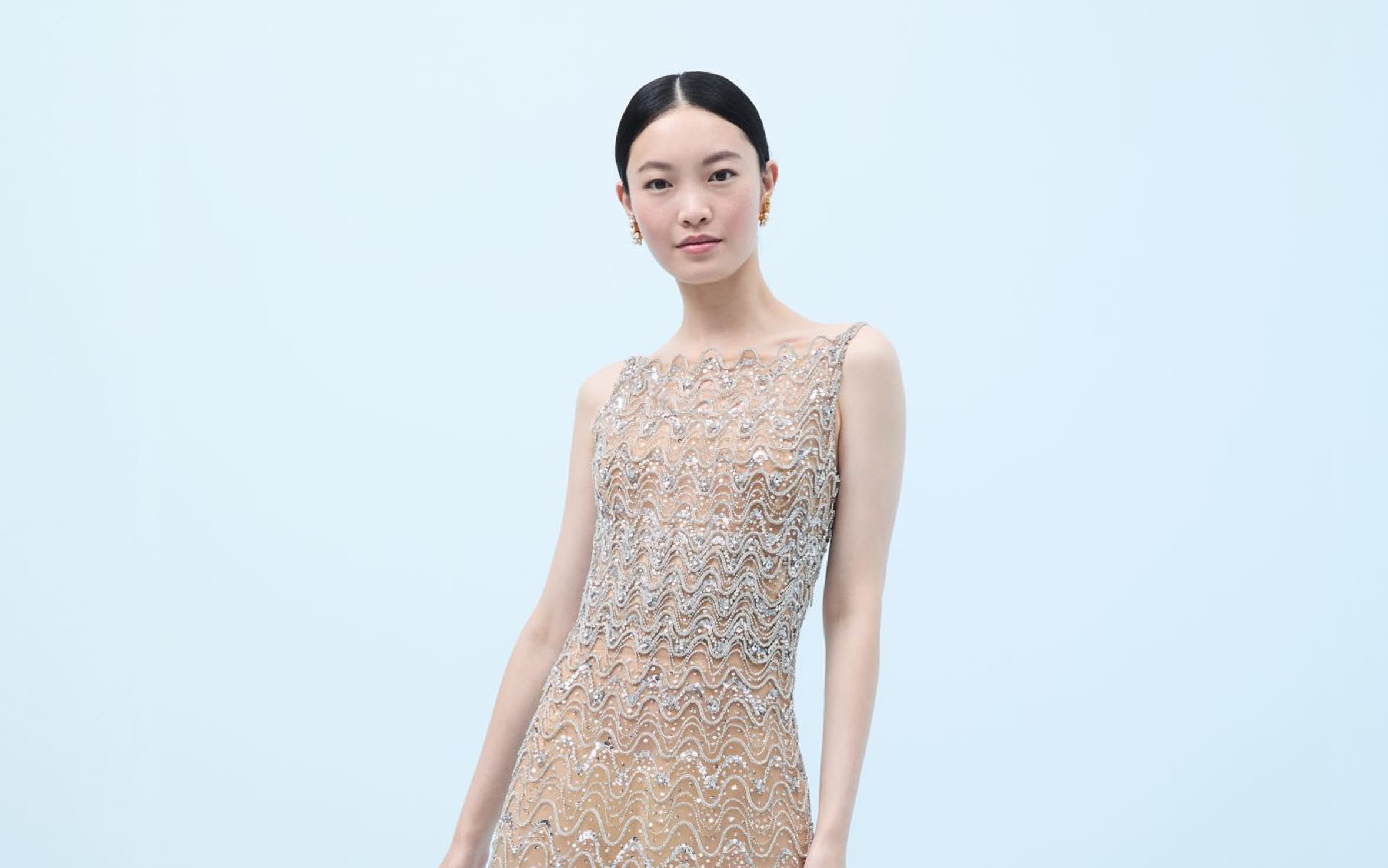 Woman wearing a crystal-embroidered evening gown and heels.