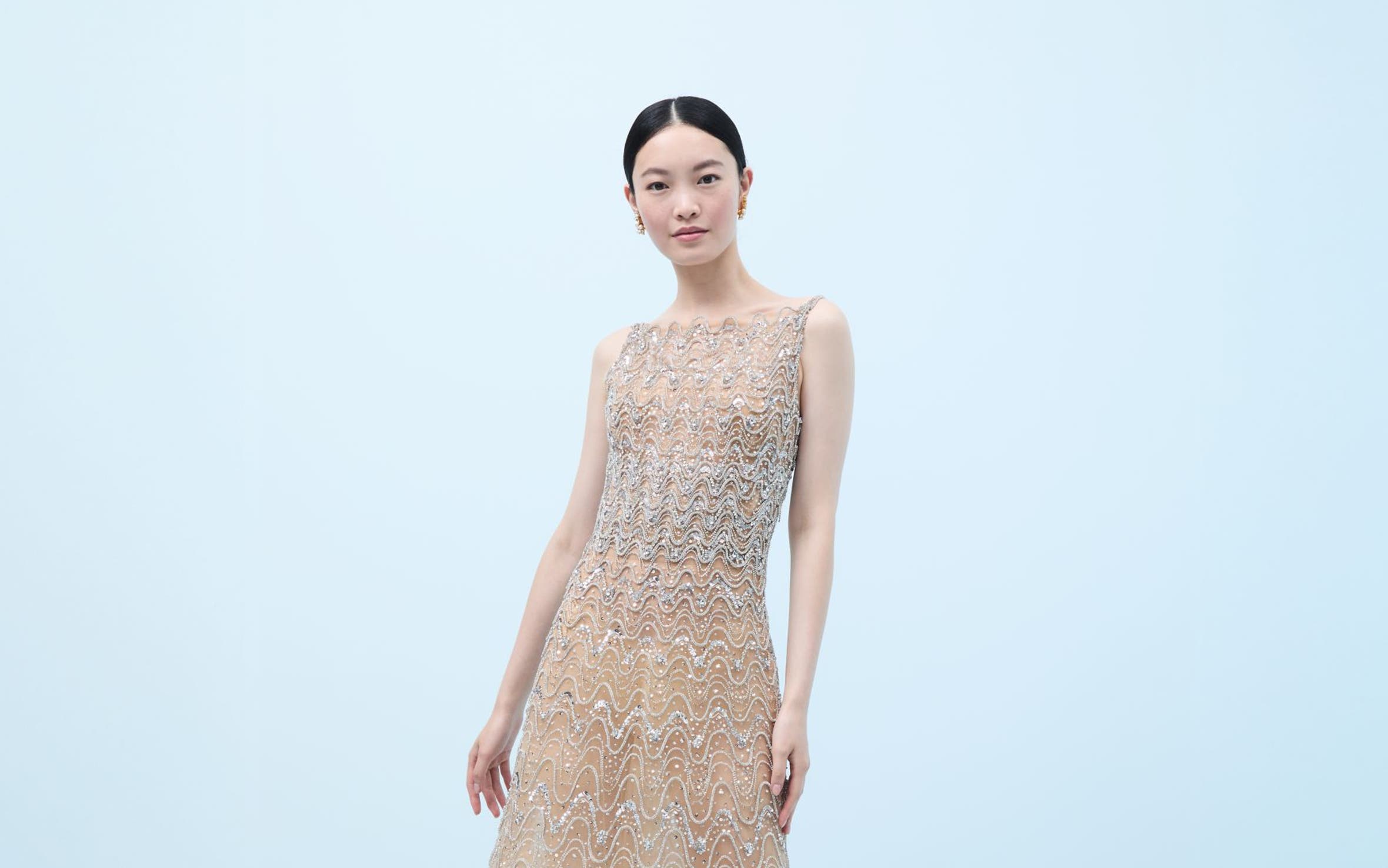 Woman wearing a crystal-embroidered evening gown and heels.