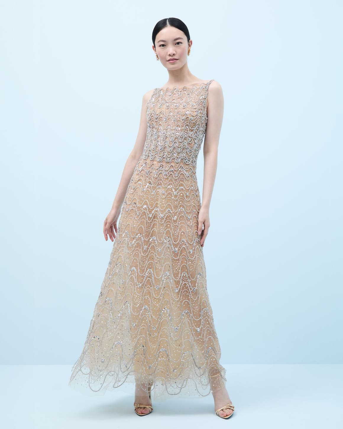 Woman wearing a crystal-embroidered evening gown and heels.