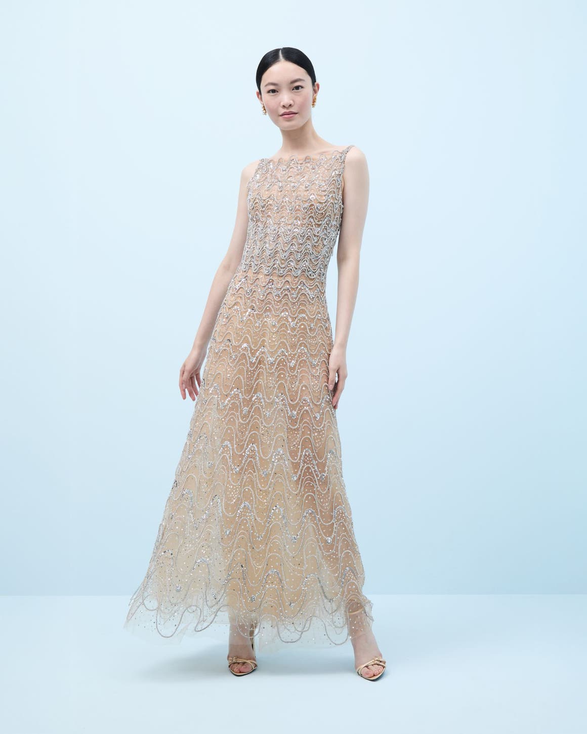 Woman wearing a crystal-embroidered evening gown and heels.