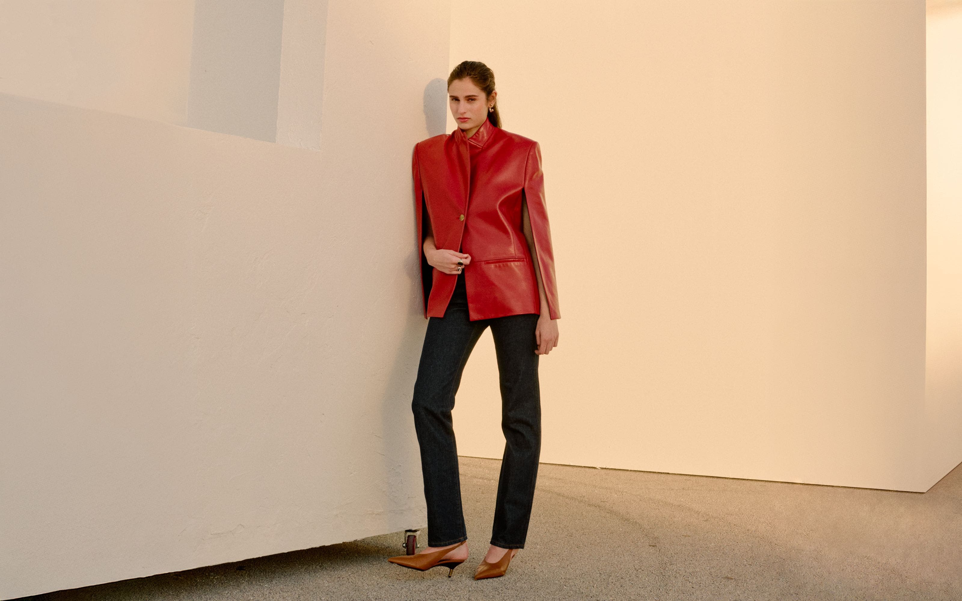 Woman wearing Khaite jacket, jeans and slingback pumps.
