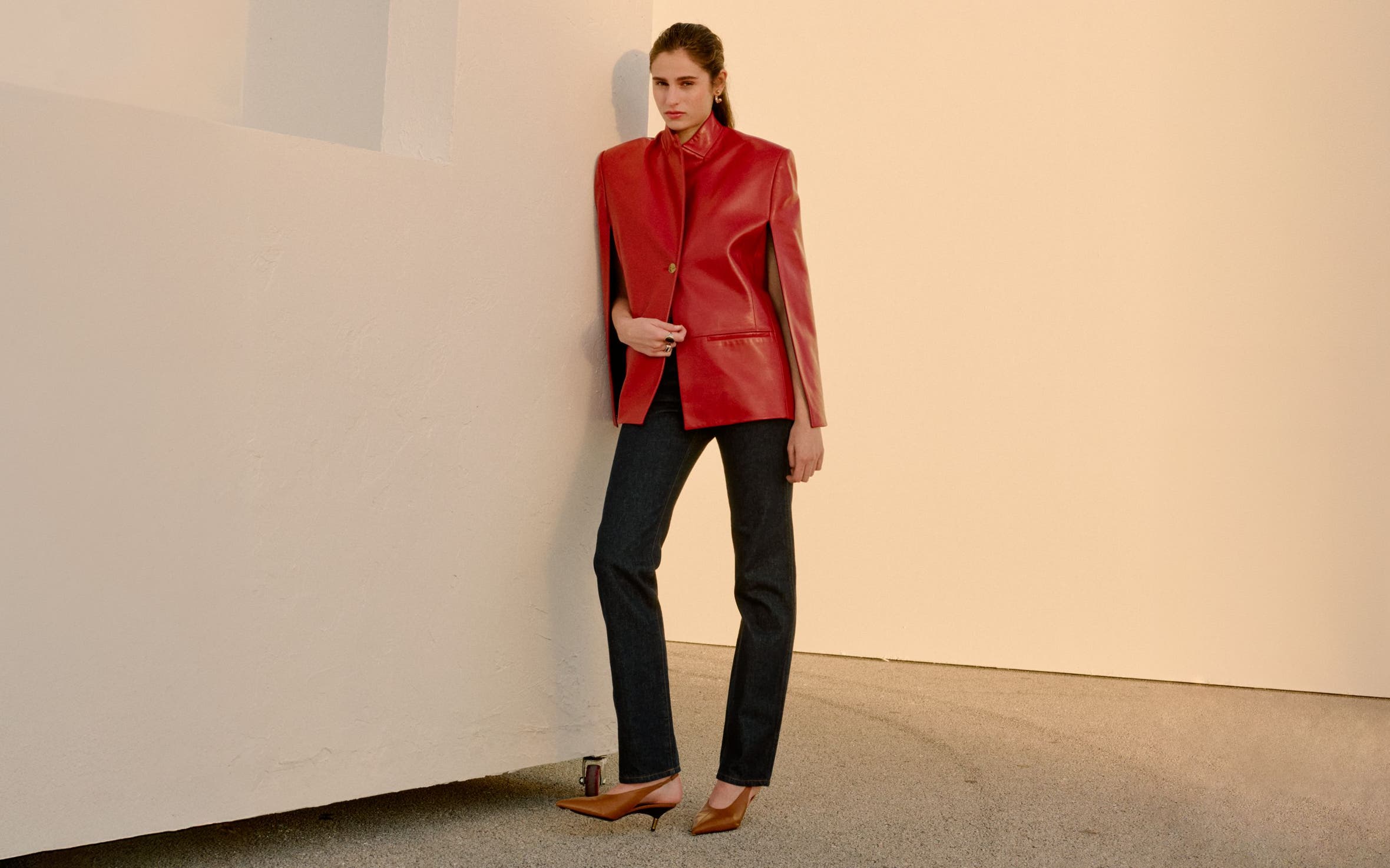 Woman wearing Khaite jacket, jeans and slingback pumps.