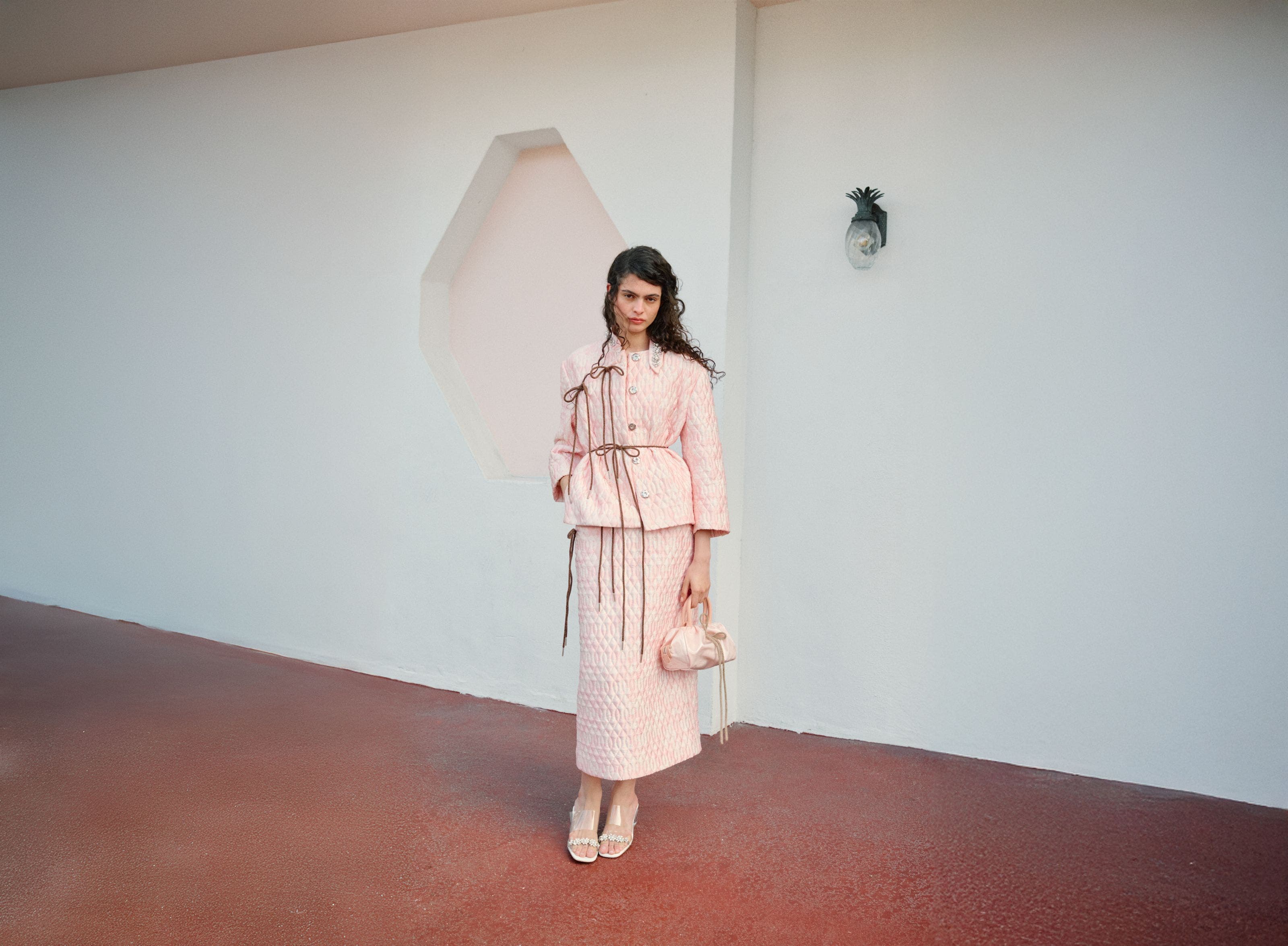 Woman wearing Simone Rocha jacket, skirts, heels and bag.