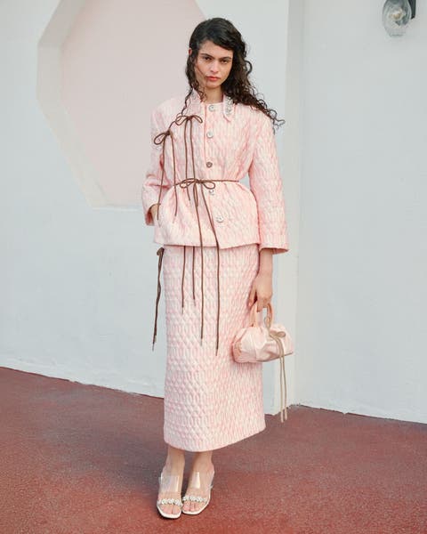 Woman wearing Simone Rocha jacket, skirts, heels and bag.