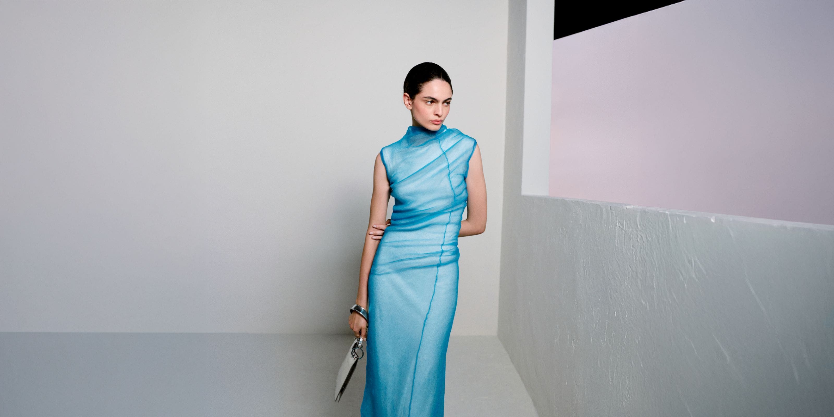 Woman wearing Jil Sander gown and clutch.