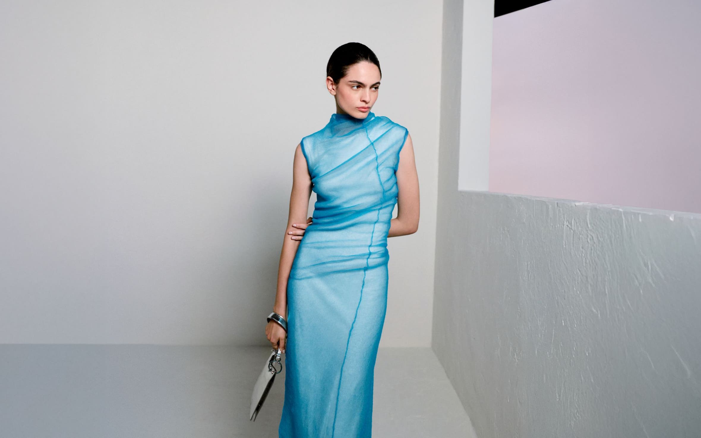 Woman wearing Jil Sander gown and clutch.