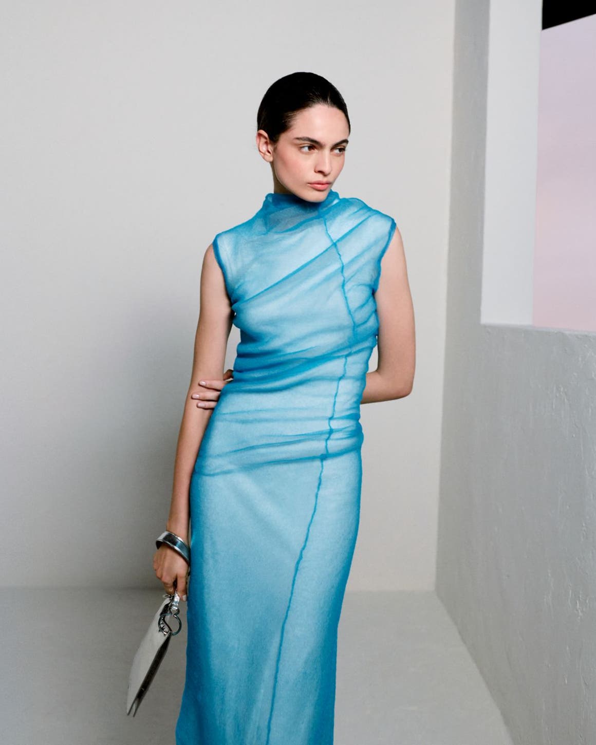 Woman wearing Jil Sander gown and clutch.
