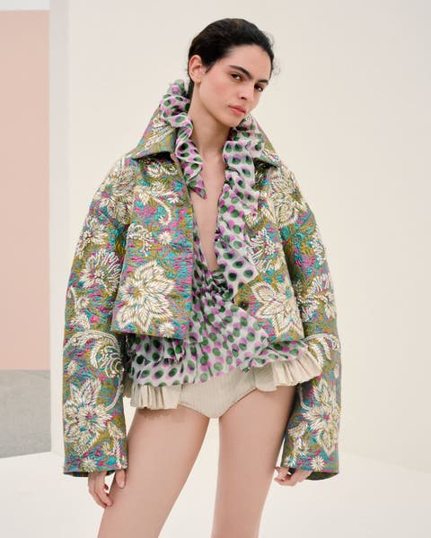 Woman wearing Dries Van Noten jacket, blouse and hot pants.