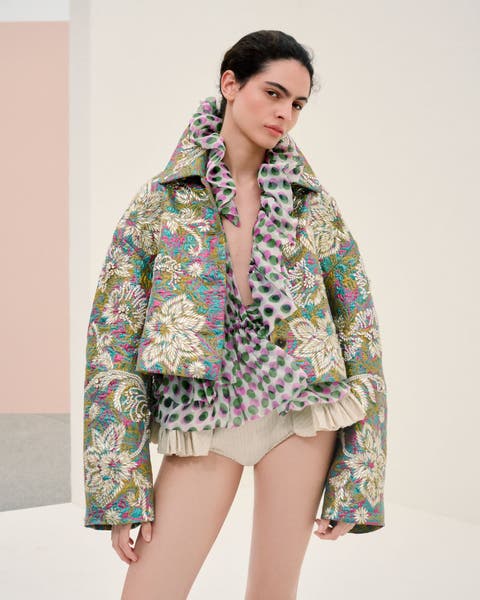 Woman wearing Dries Van Noten jacket, blouse and hot pants.