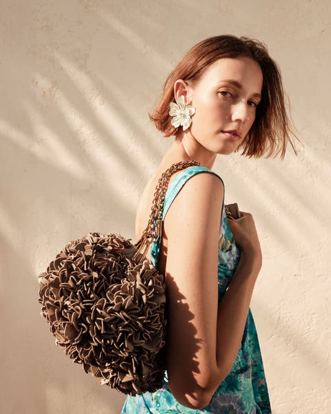 Woman holding a textured Chloé handbag.