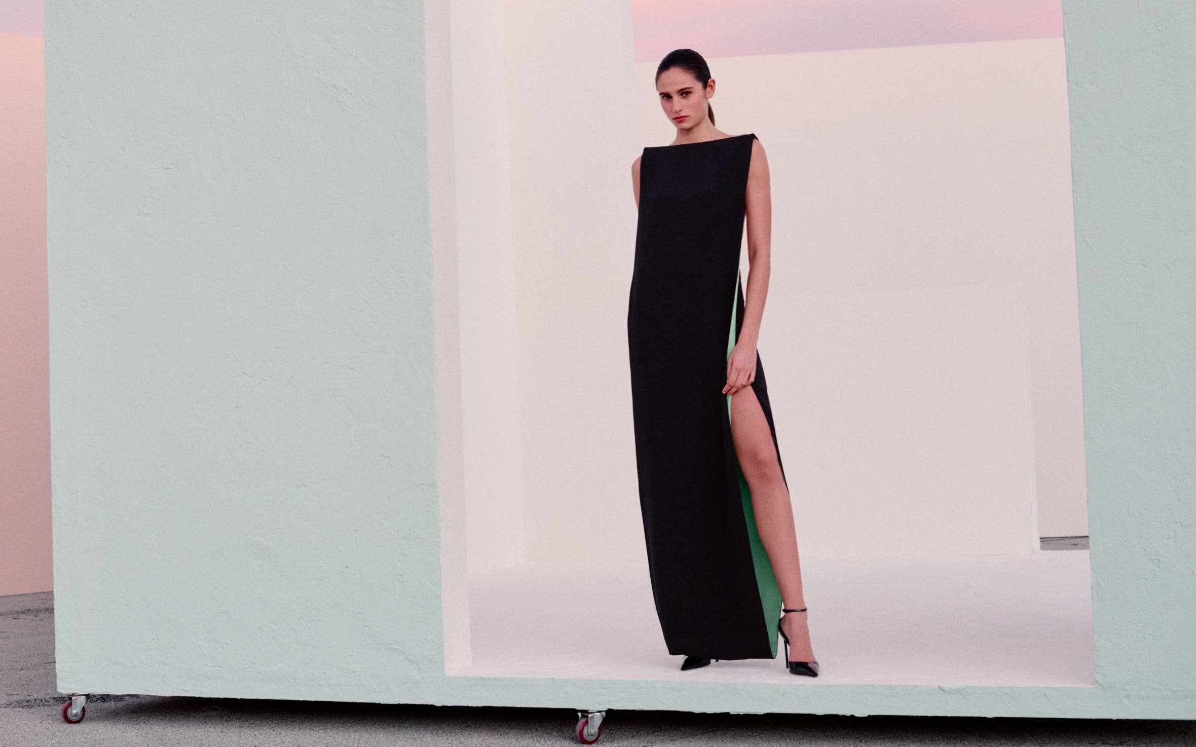 Woman wearing a black evening gown and heels.