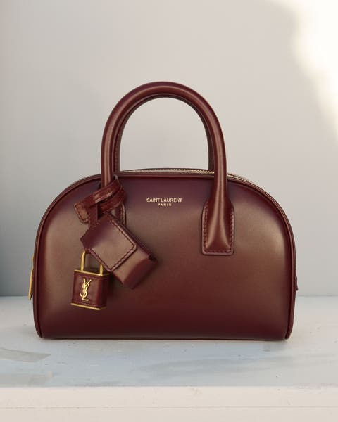 Structured top-handle handbag in burgundy leather with gold hardware.