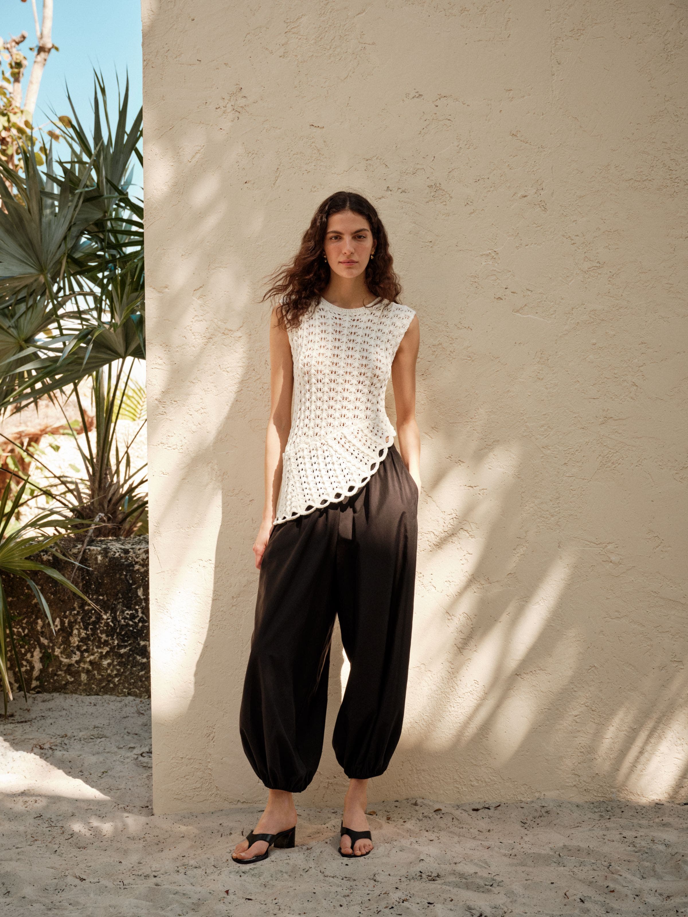 Woman wearing LOULOU DE SAISON top and pants with Christian Louboutin heeled sandals.