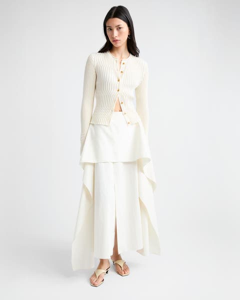 Woman wearing a cardigan and long layered skirt with sandals.