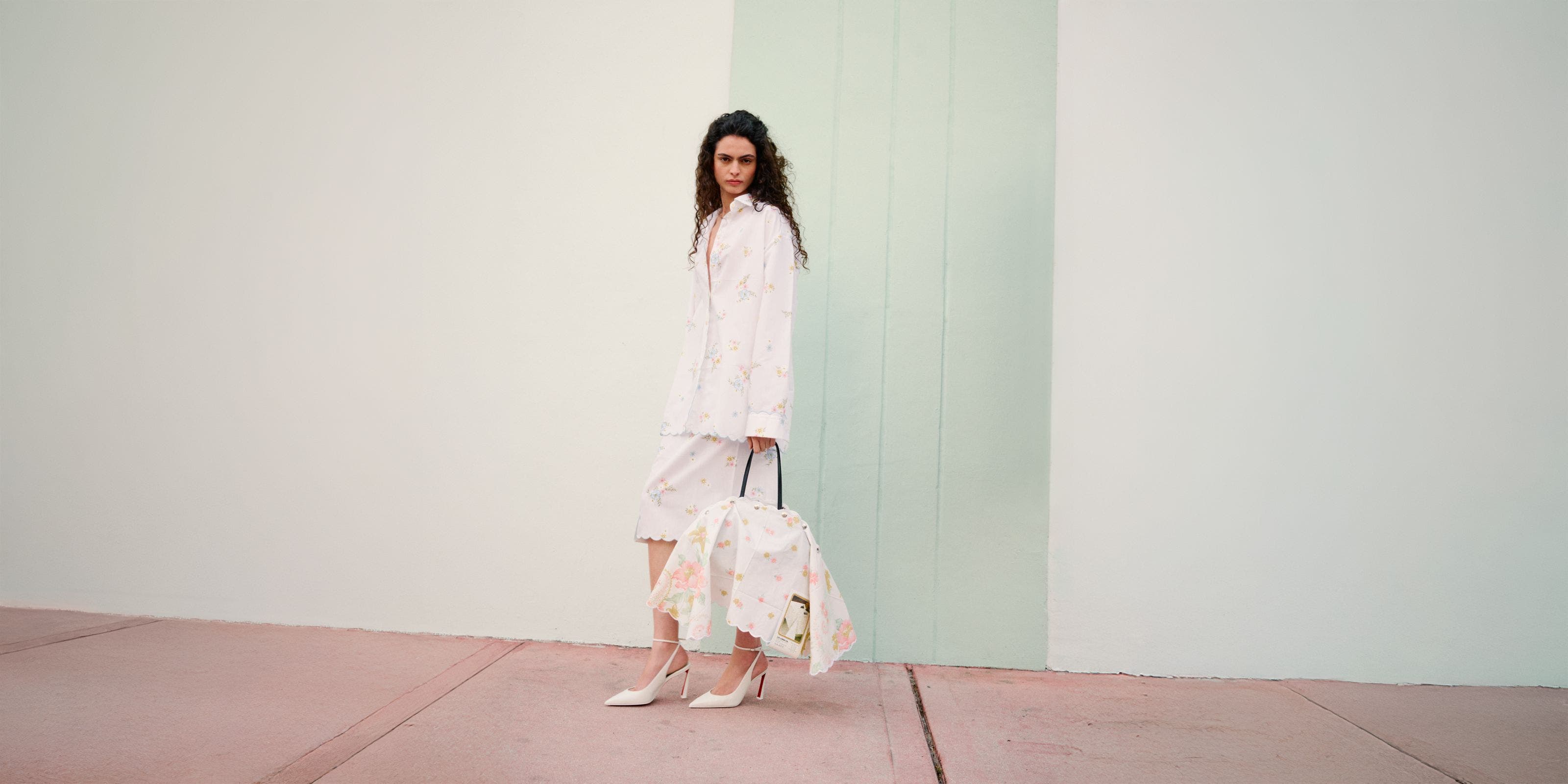 Woman wearing Julie Kegels jacket, skirts, heels and bag.