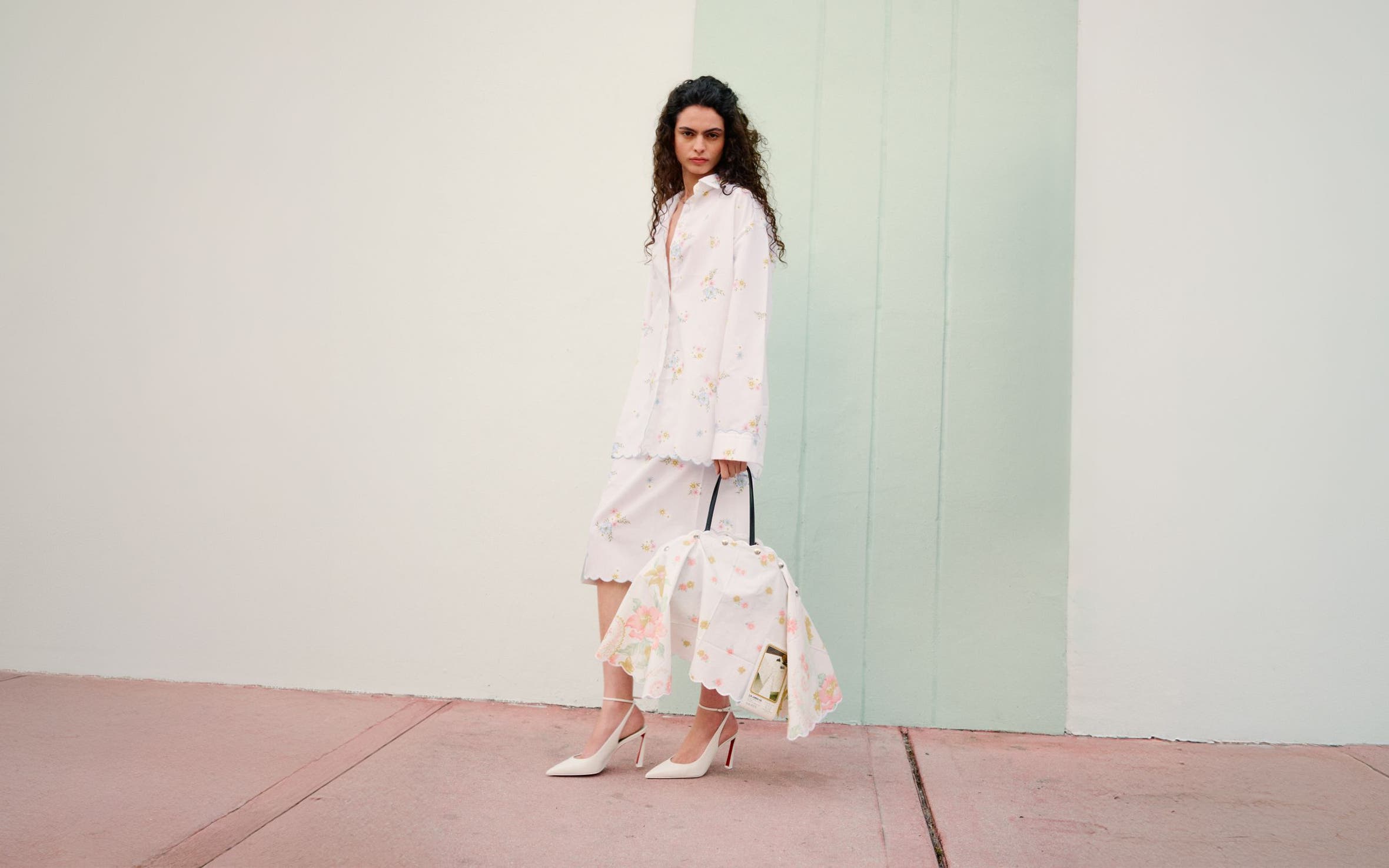 Woman wearing Julie Kegels jacket, skirts, heels and bag.