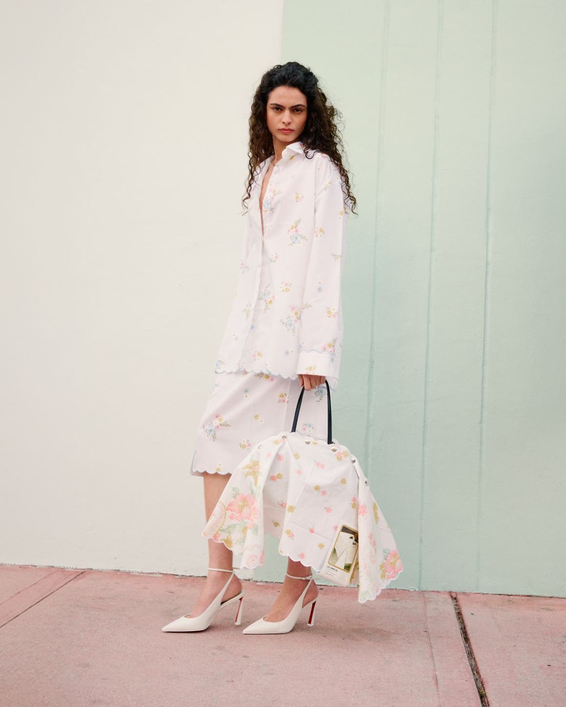 Woman wearing Julie Kegels jacket, skirts, heels and bag.