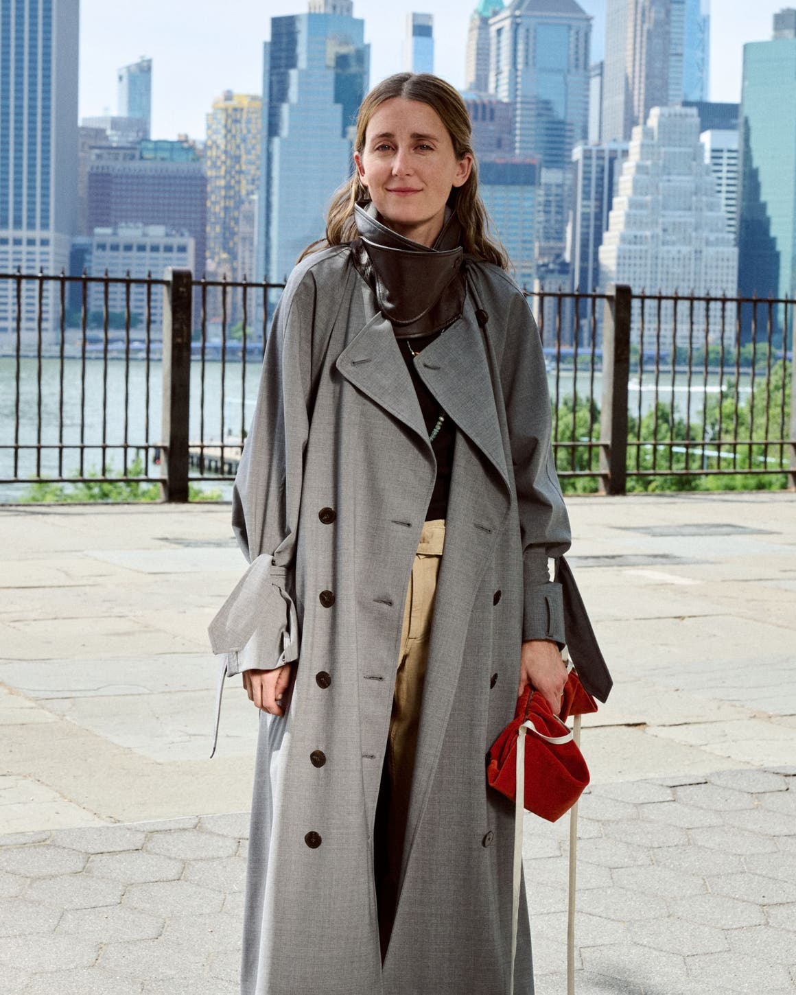 Woman in a long grey coat standing on a city street