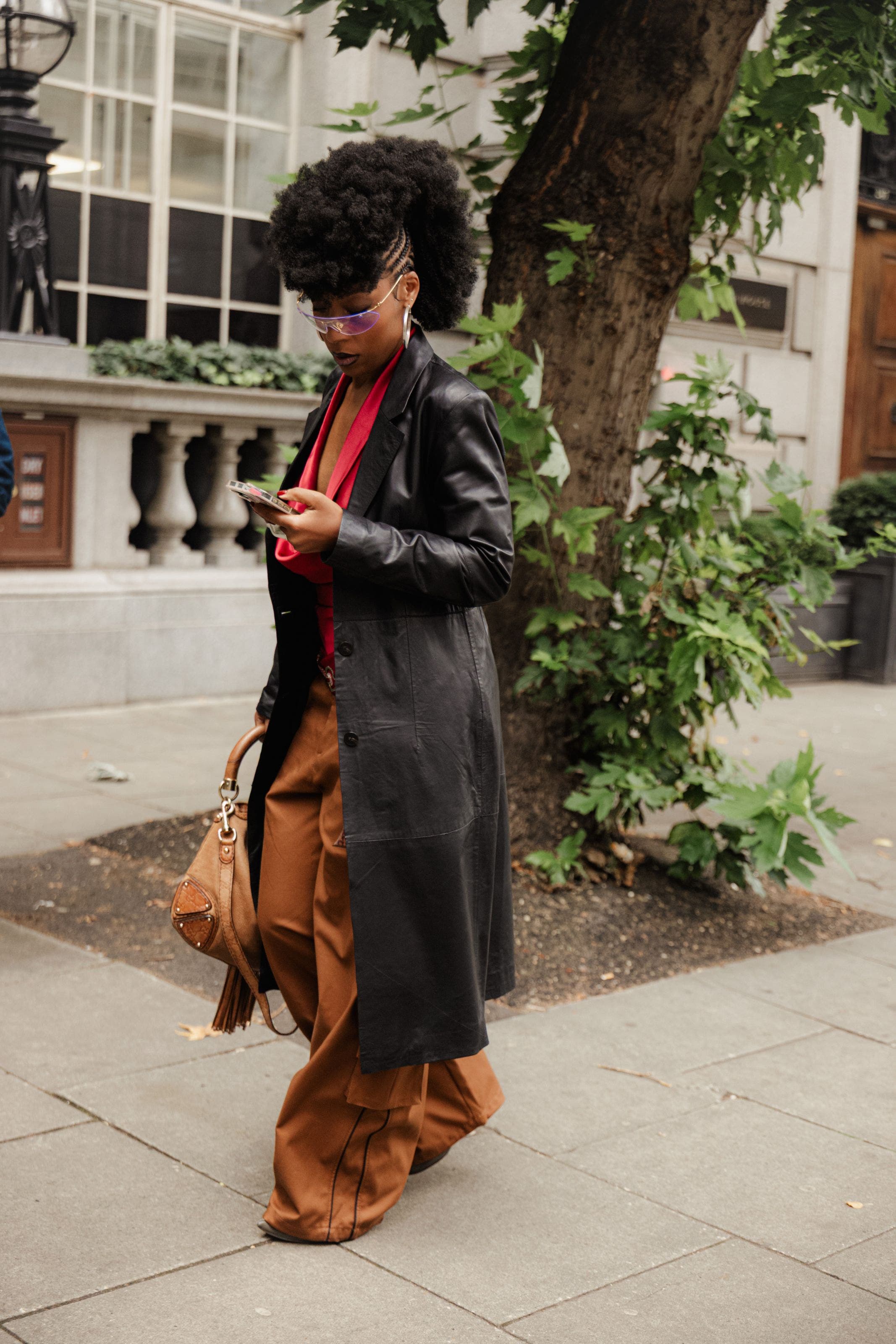 A woman in a long leather coat outside the shows at London Fashion Week.