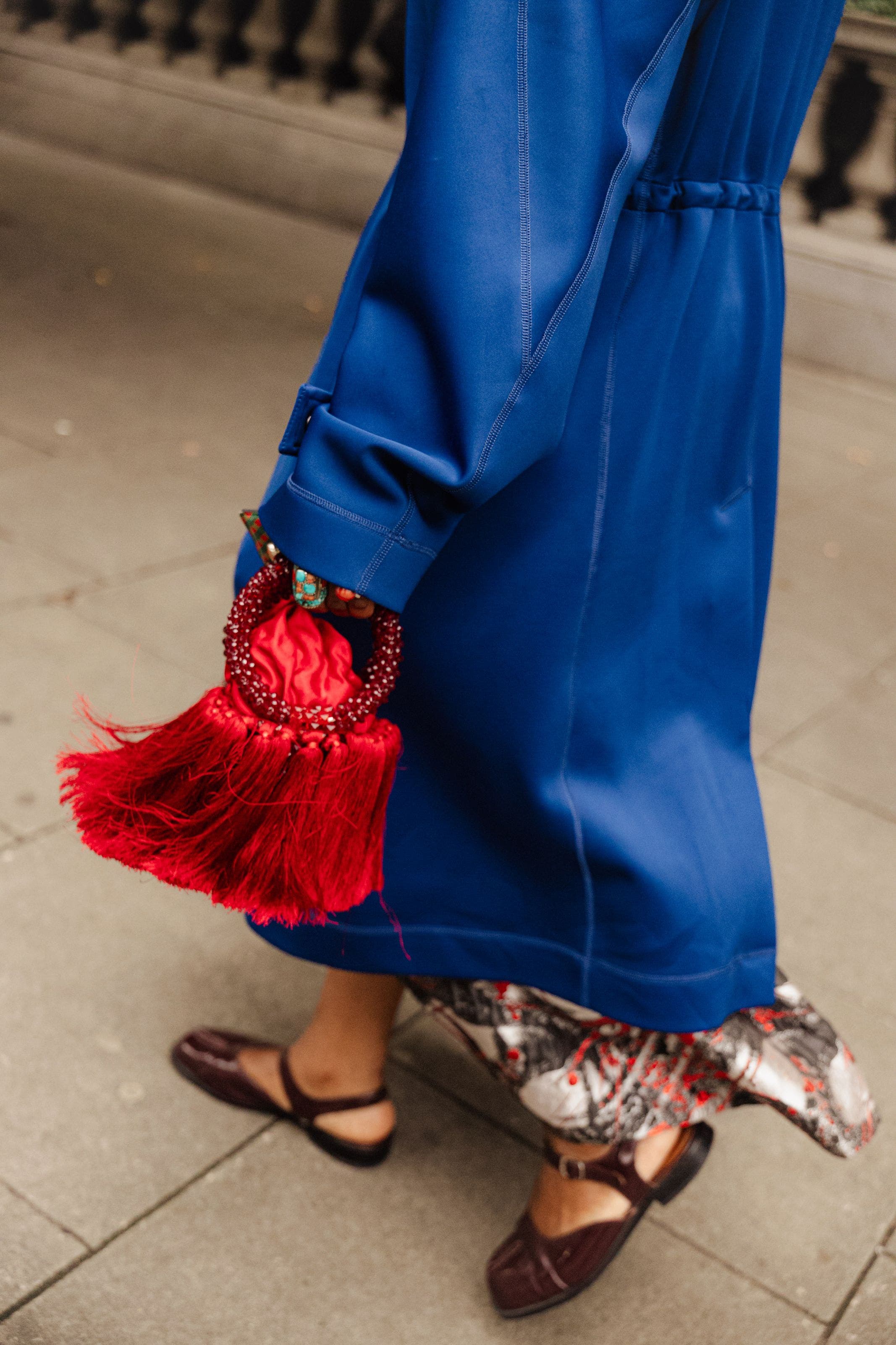 A woman with a red tasseled handbag outside the shows at London Fashion Week.