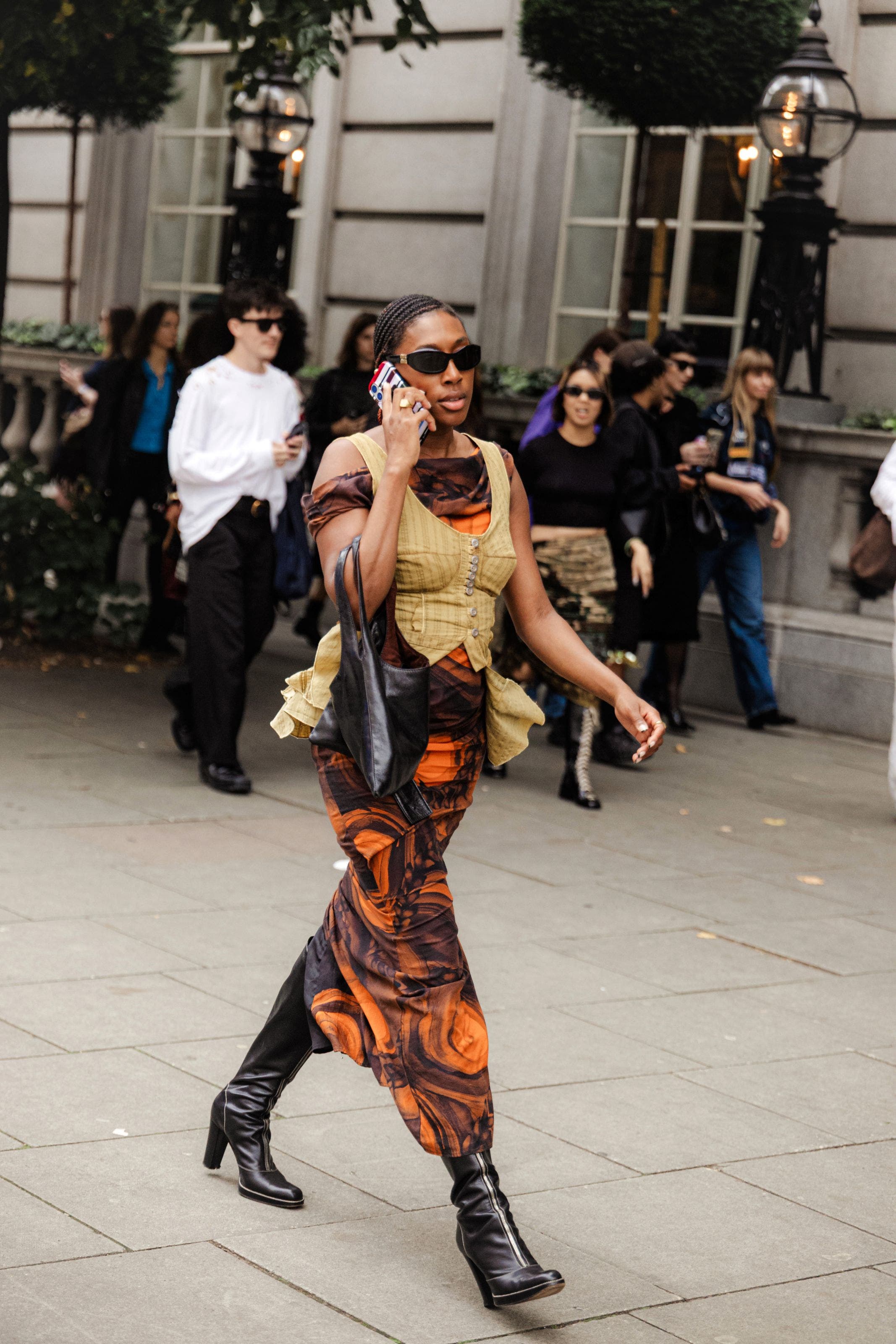 A woman in a dress and vest outside the shows at London Fashion Week.