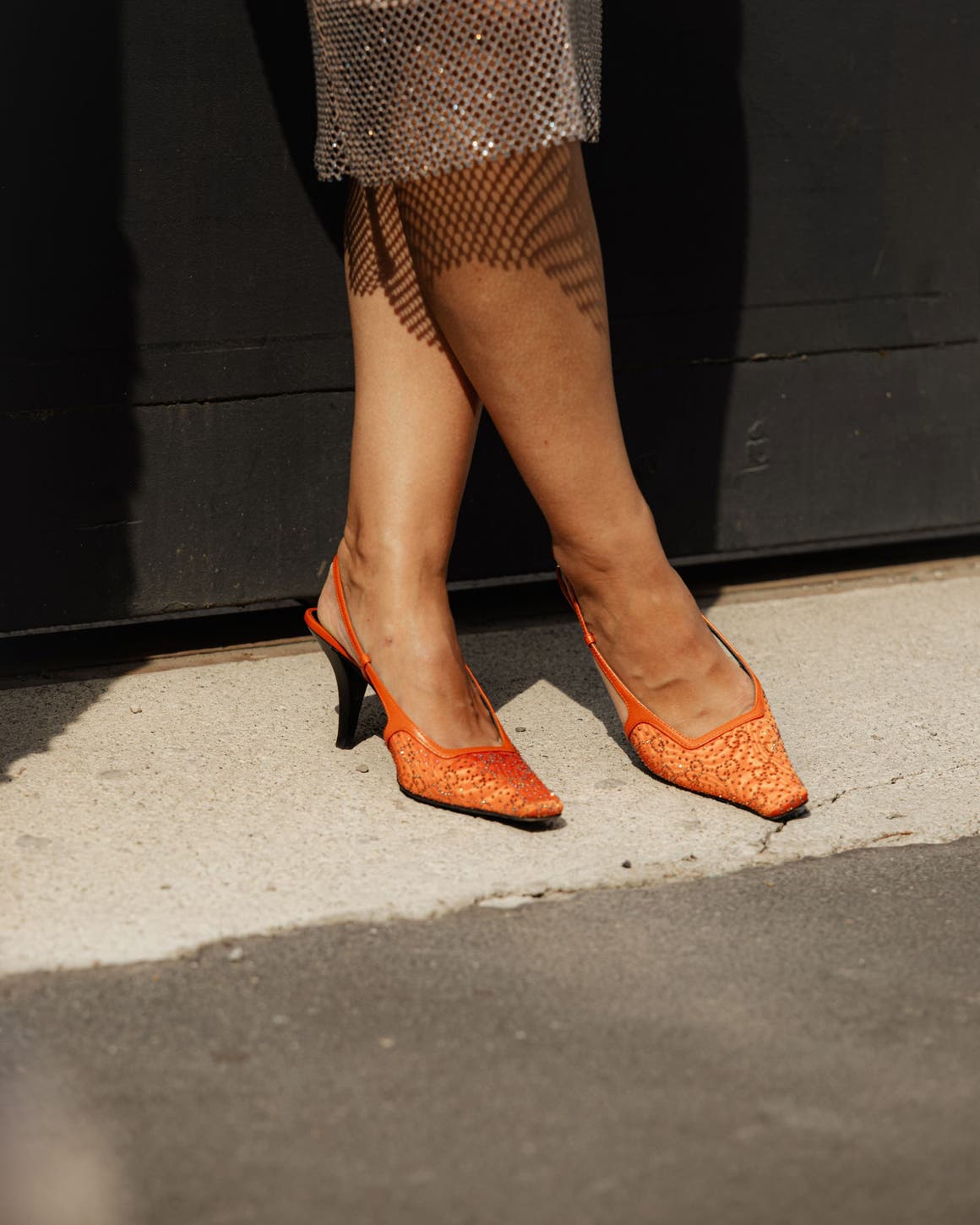 Woman wearing orange slingback sandals.