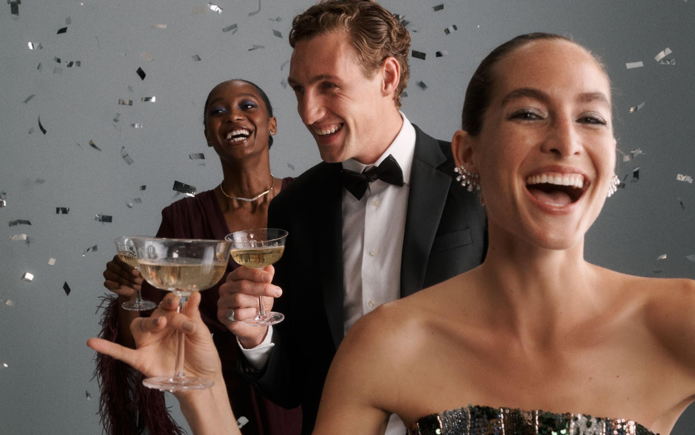 Three people holding glasses of champagne.