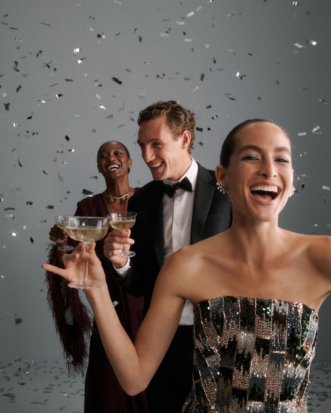 Three people holding glasses of champagne.