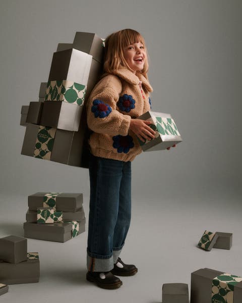 A girl holding Nordstrom gift boxes.