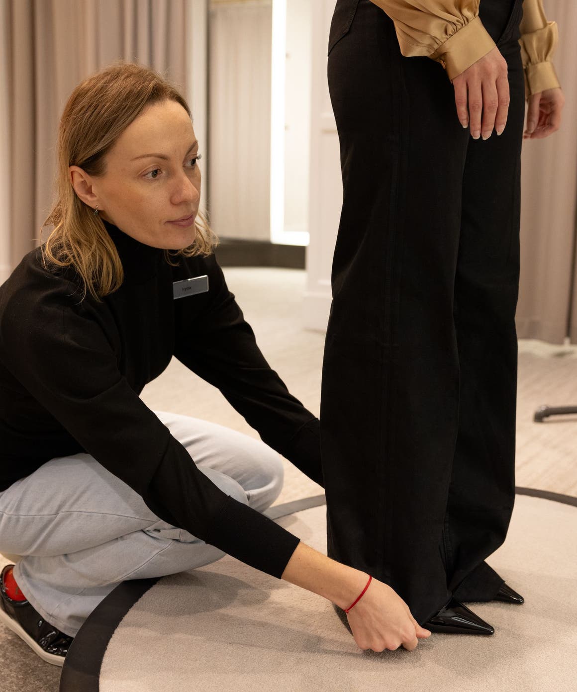 Woman fixing a pant leg.