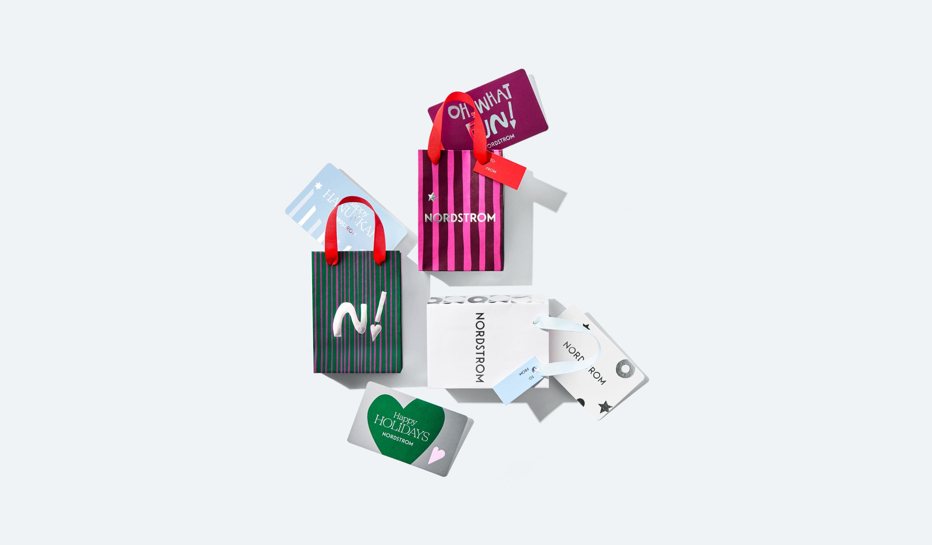An assortment of holiday gift cards and Nordstrom gift bags.