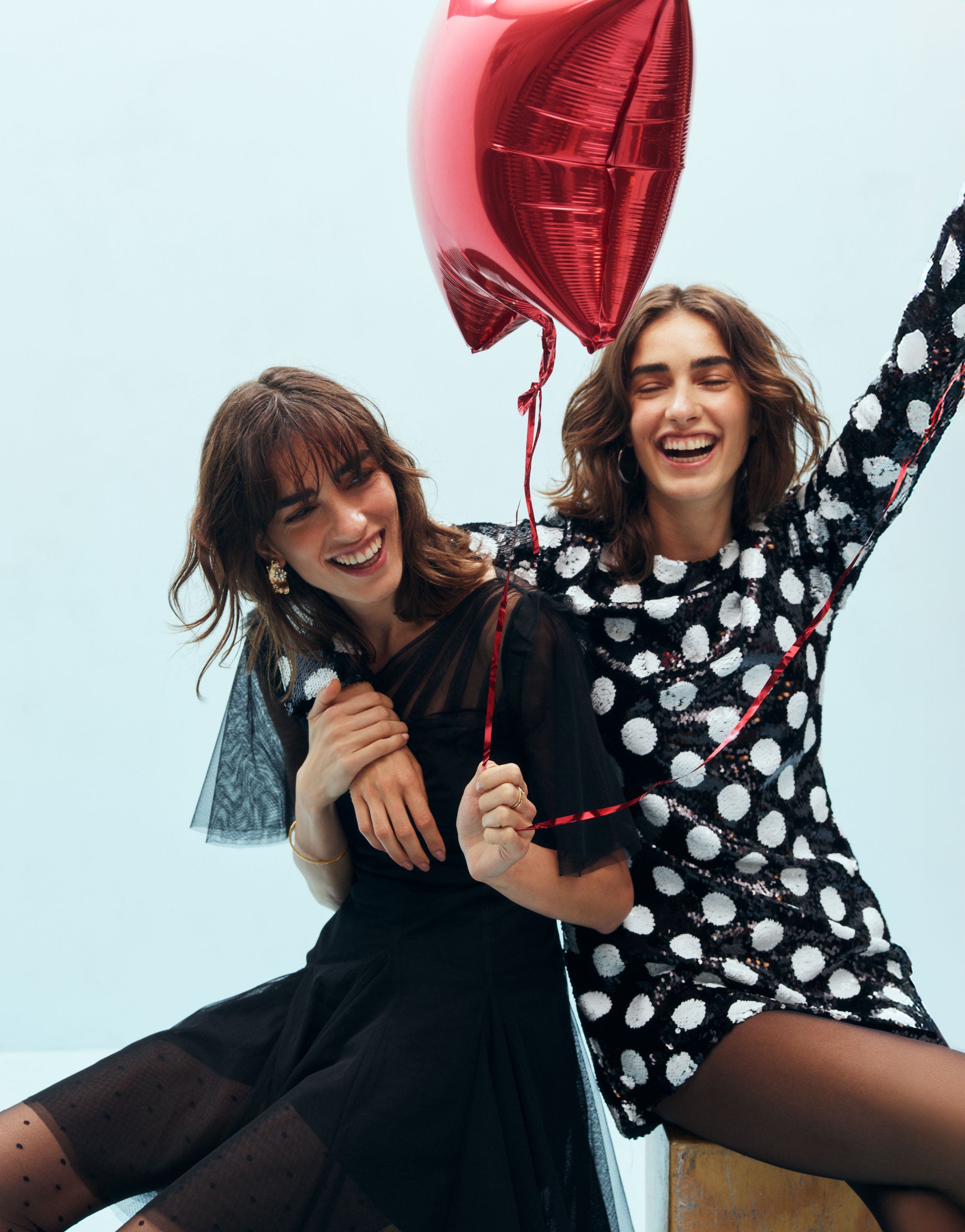 Two women wearing party dresses.