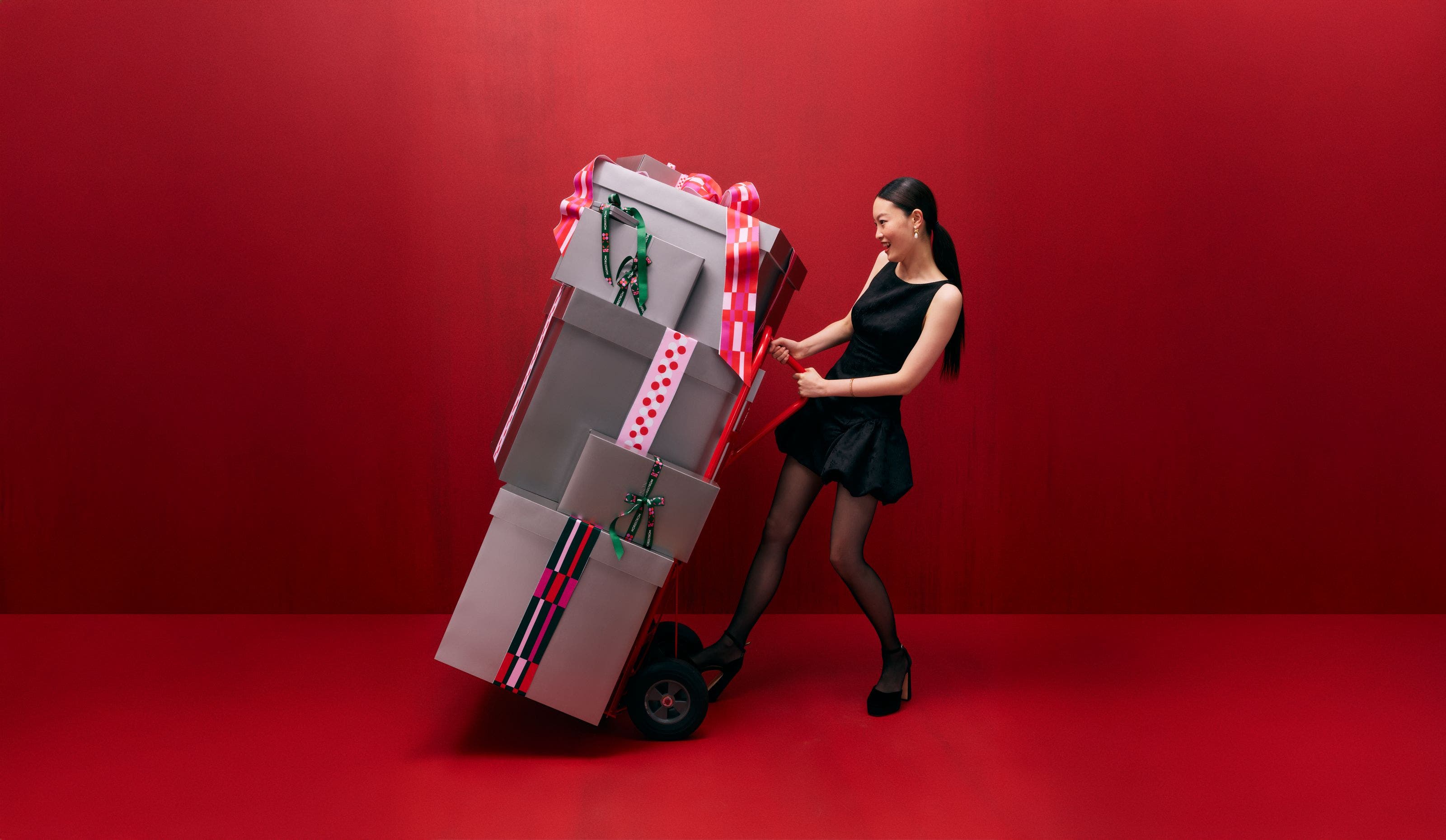 Woman wheeling Nordstrom gifts.