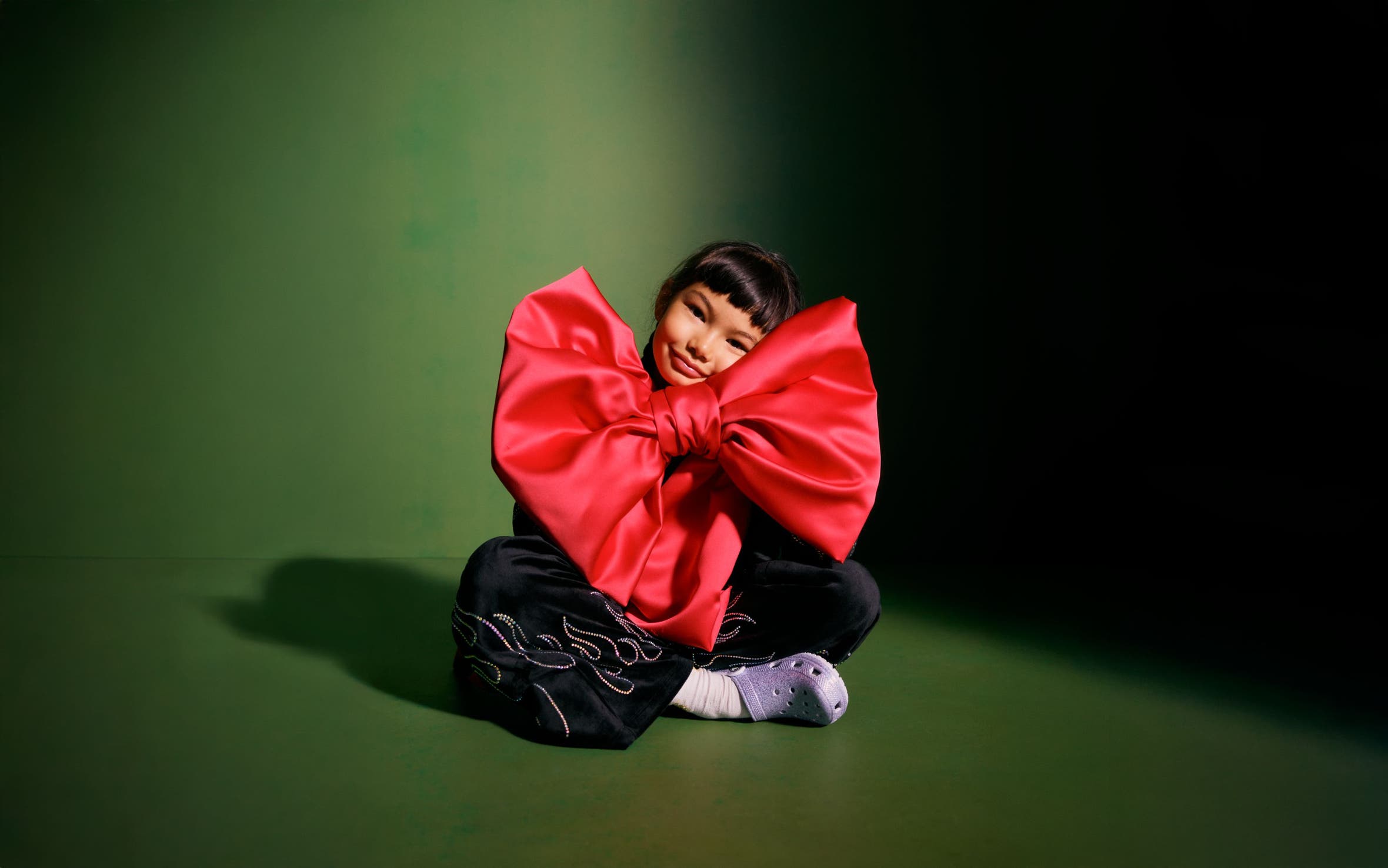 A girl holding a giant red bow.