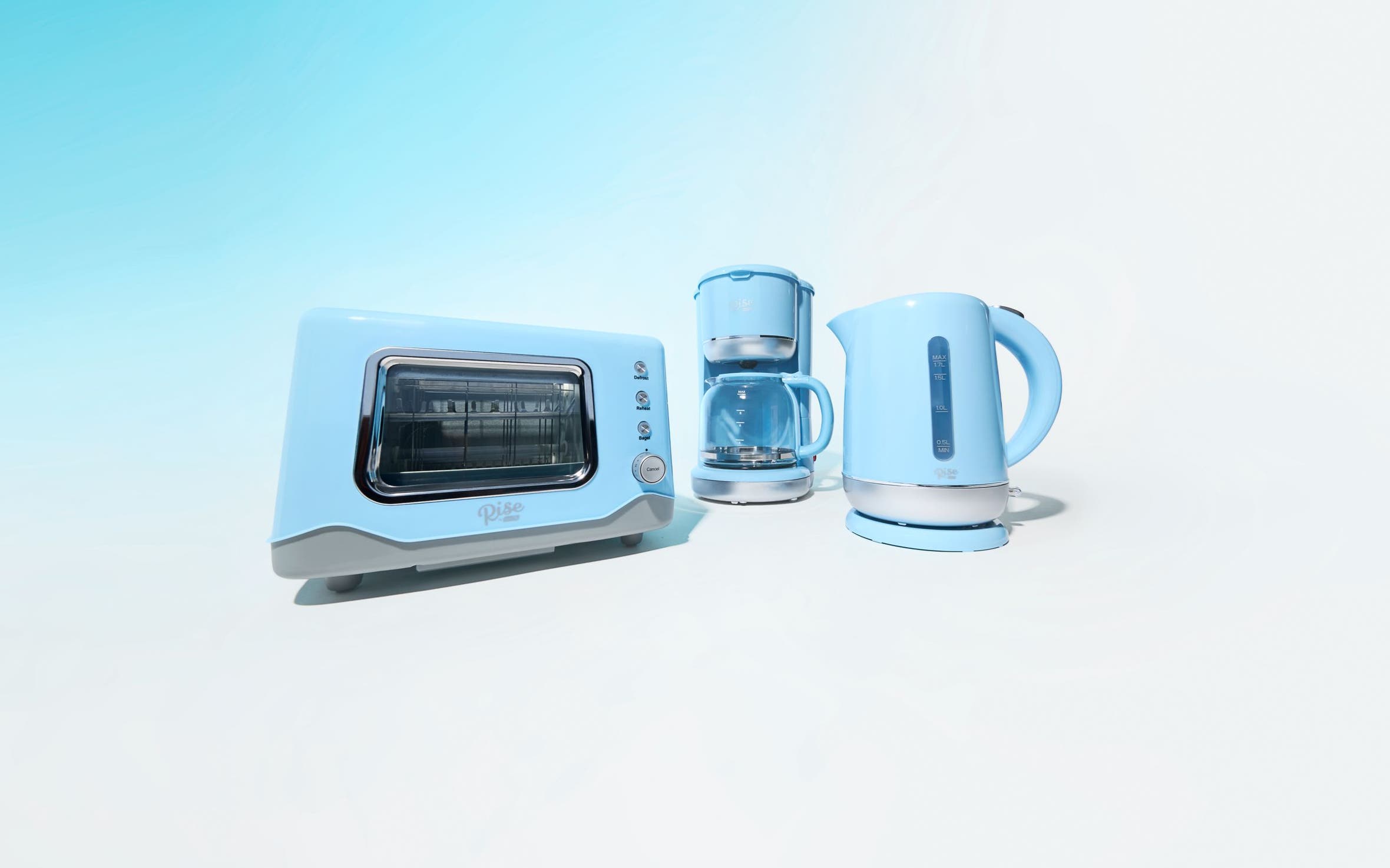 A light-blue toaster oven, coffeemaker and electric kettle.