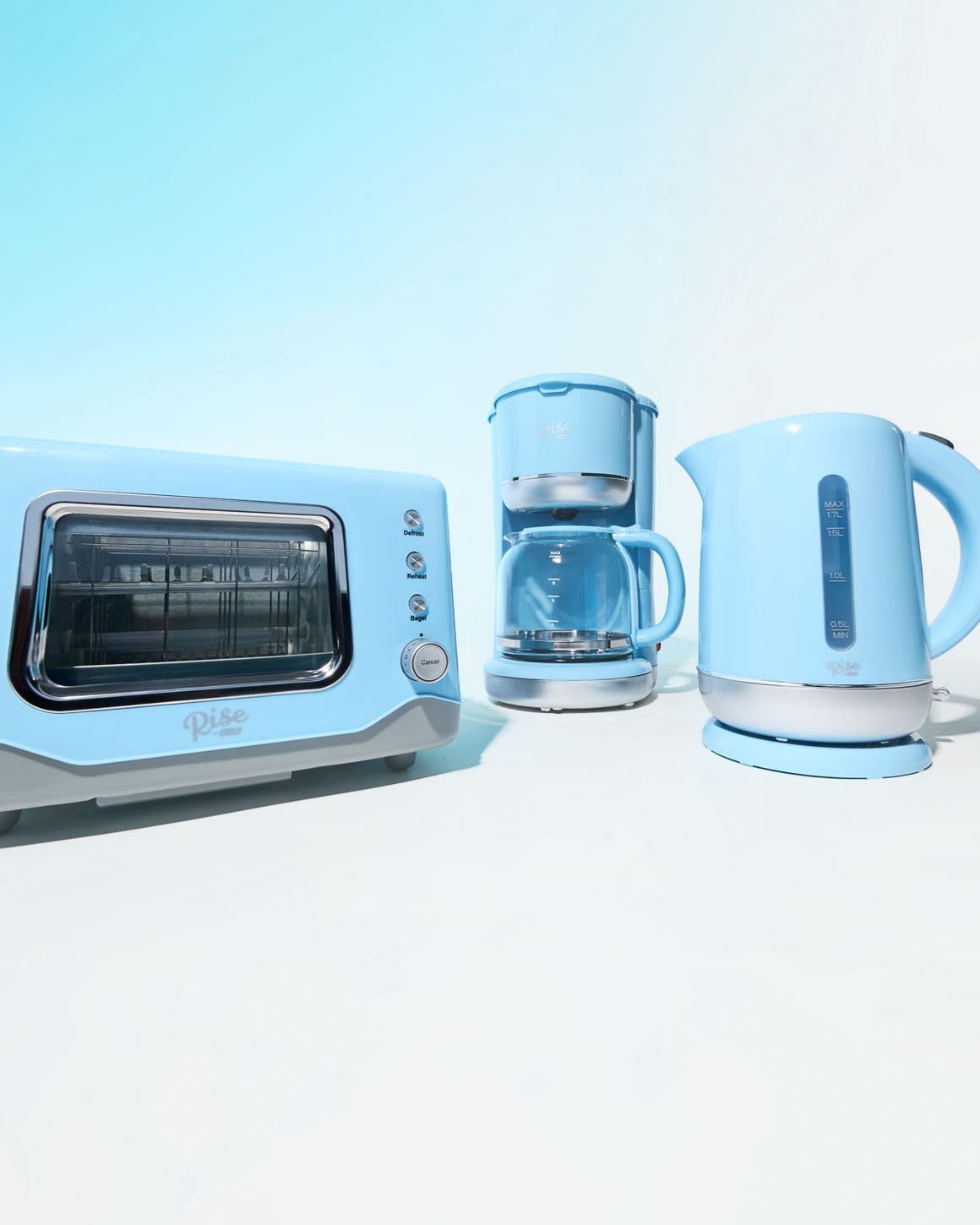 A light-blue toaster oven, coffeemaker and electric kettle.
