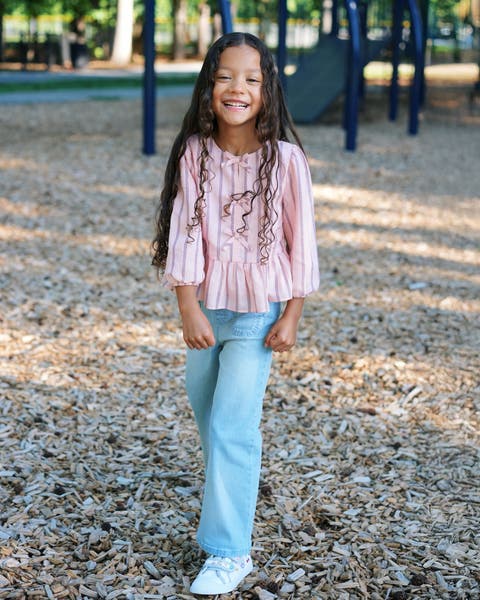 A girl wearing a cute back-to-school outfit.