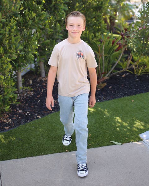 A boy wearing a casual back-to-school outfit.