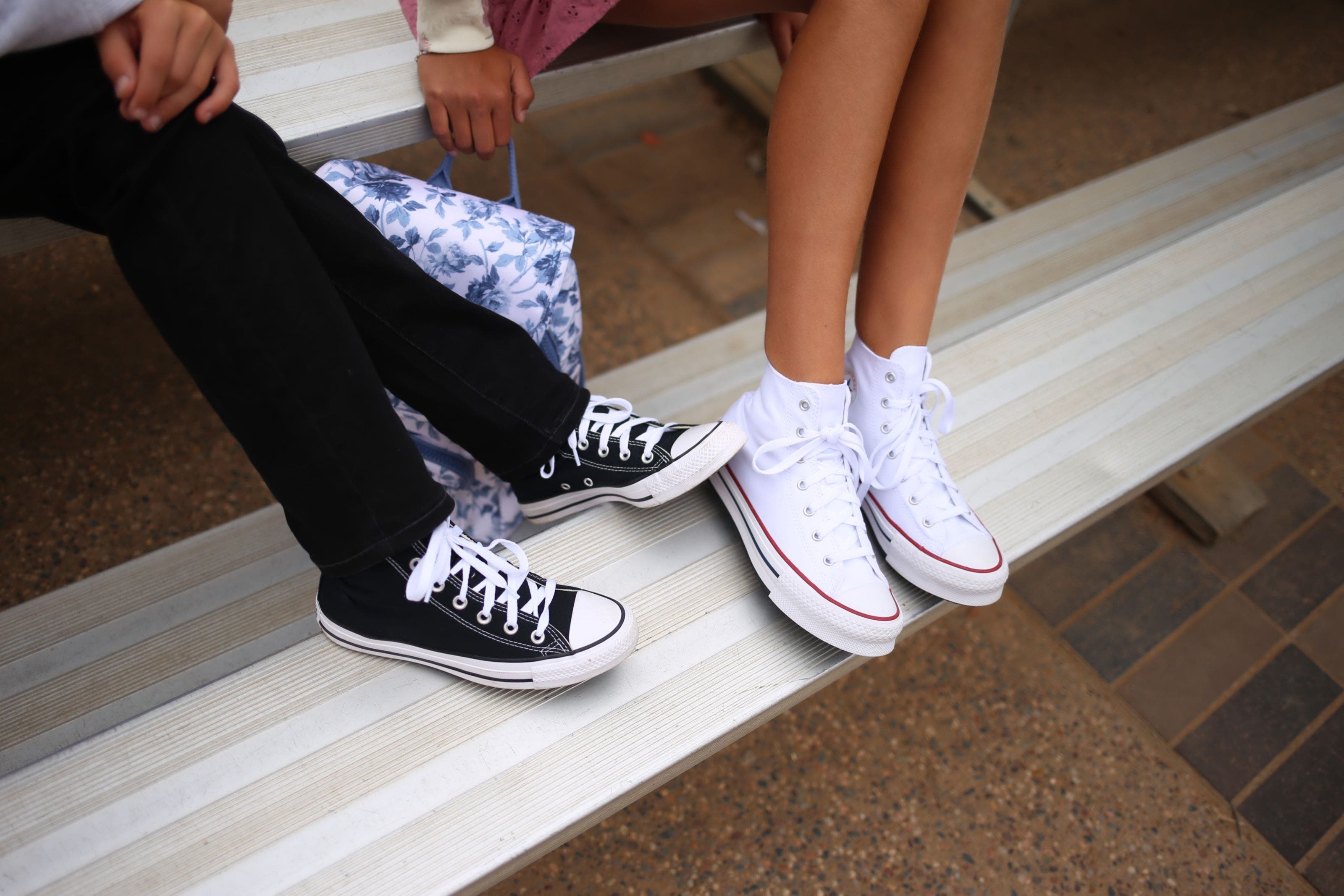 Two kids wearing Converse sneakers.
