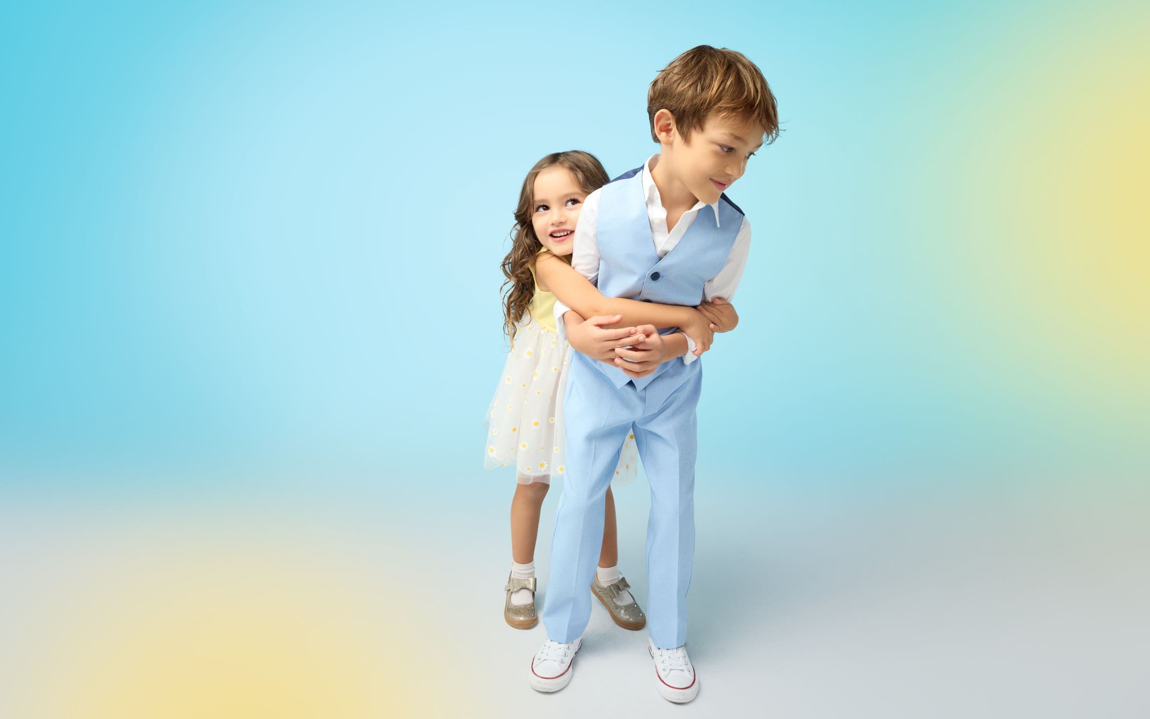 A girl in a white dress and a boy in a blue suit.