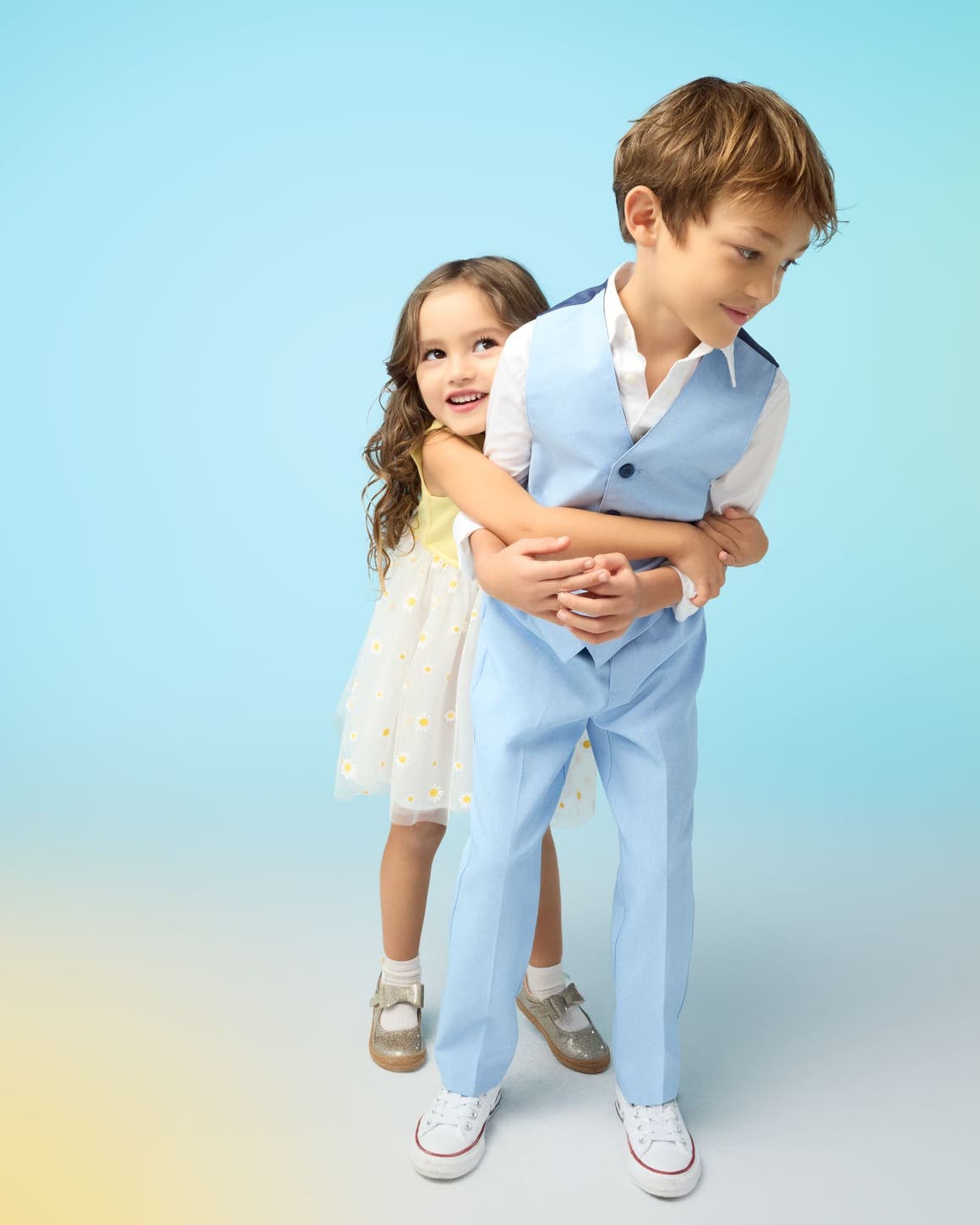 A girl in a white dress and a boy in a blue suit.
