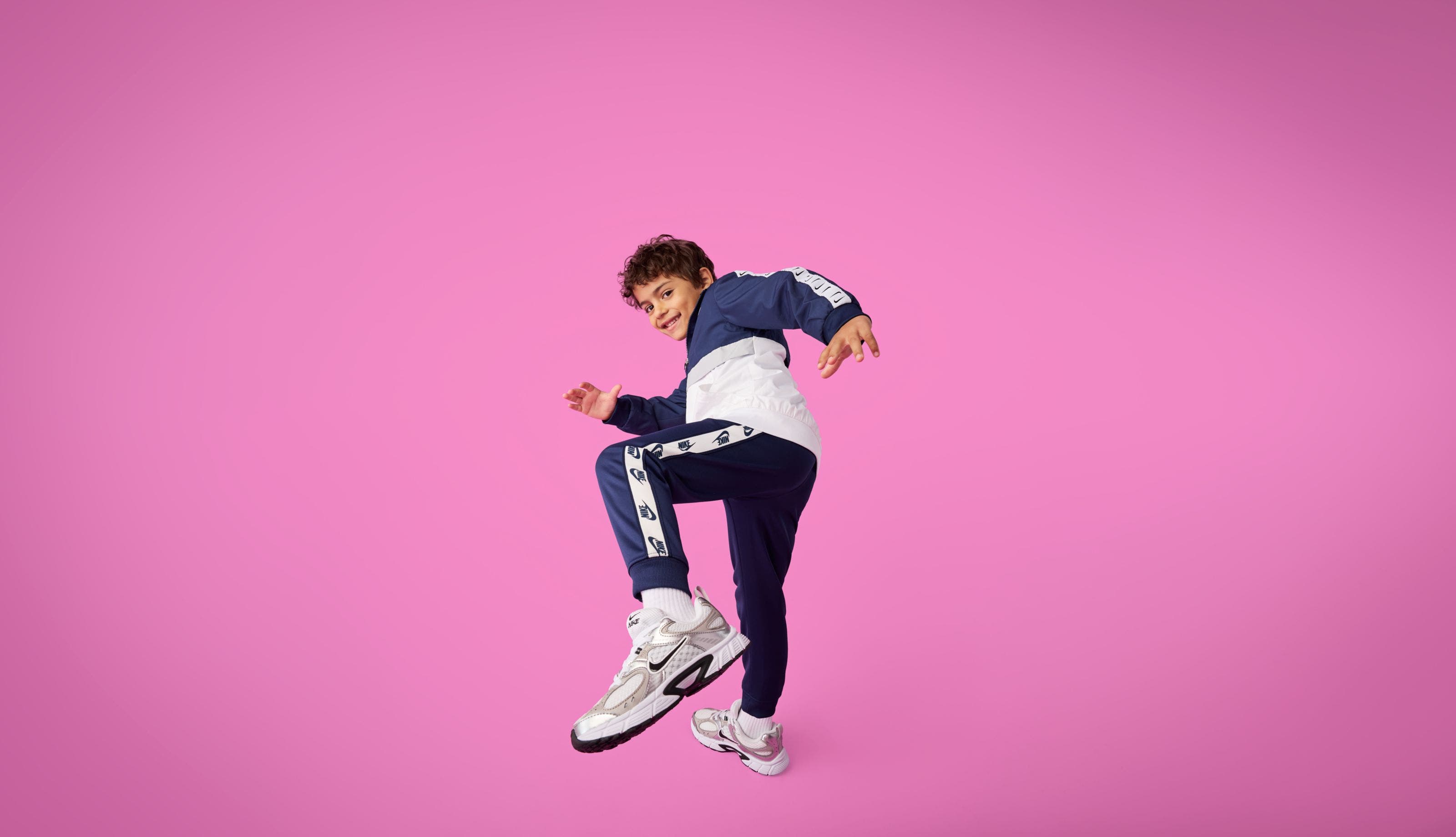 A boy wearing a matching Nike jacket and sweatpants.