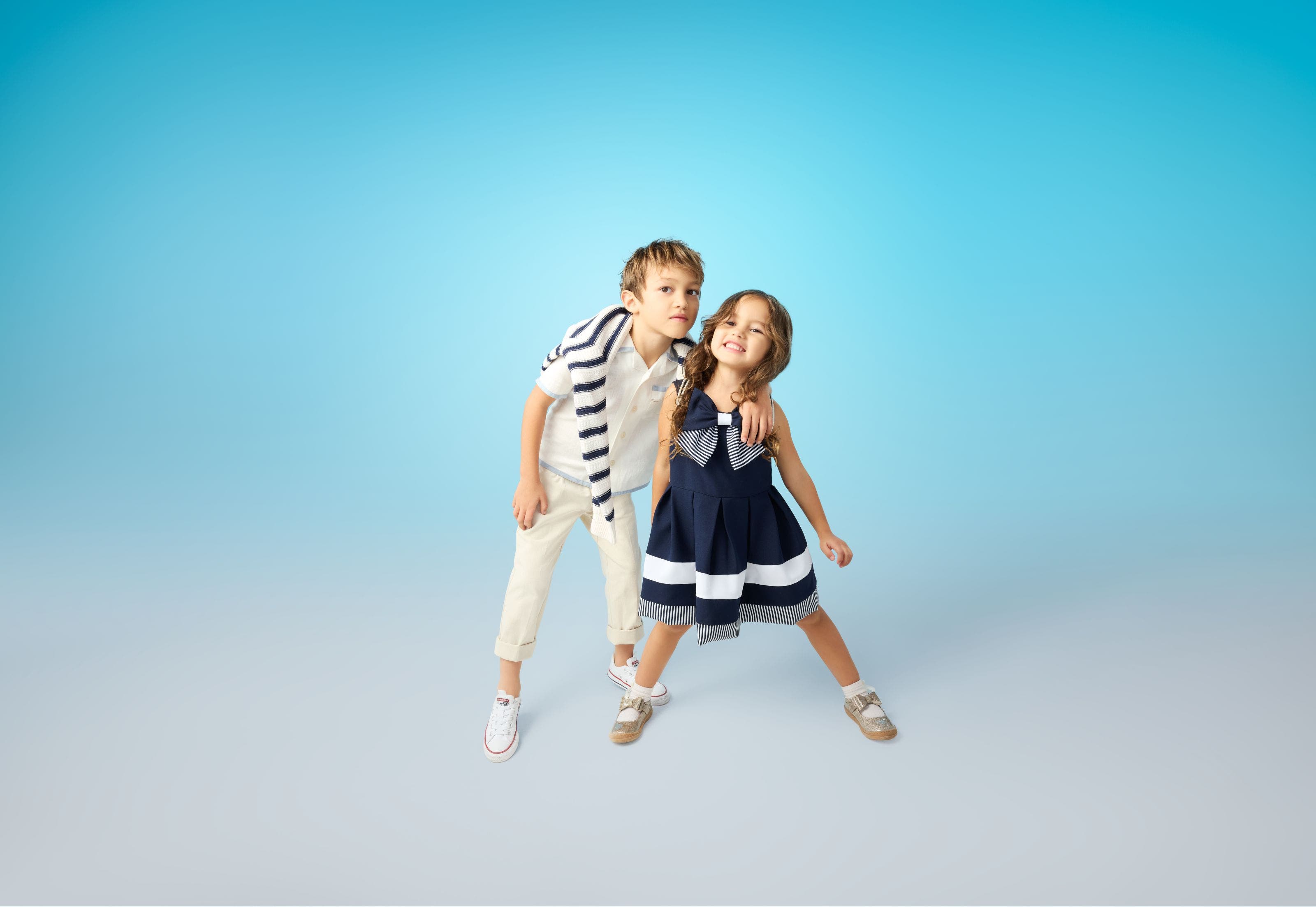 Two children dressed in blue-and-white outfits.