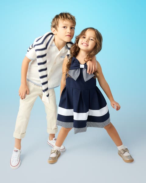 Two children dressed in blue-and-white outfits.