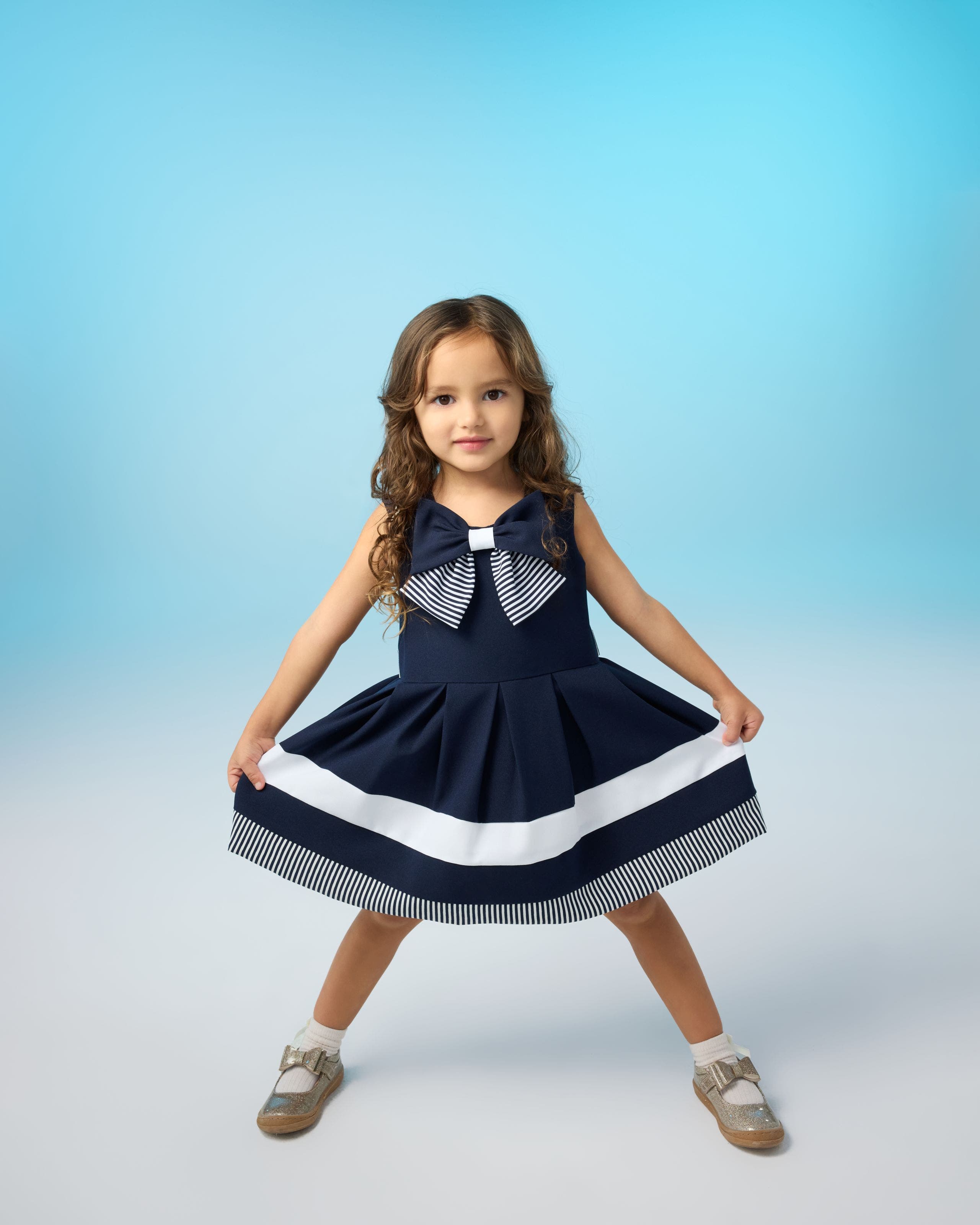 A child wearing a blue dress with stripes.