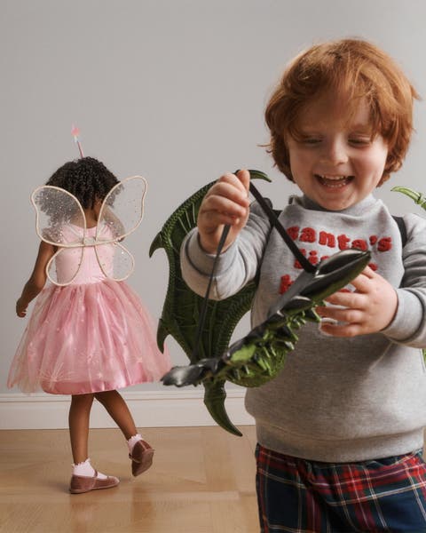 A boy wearing a mask and wings and a girl wearing a fairy outfit.