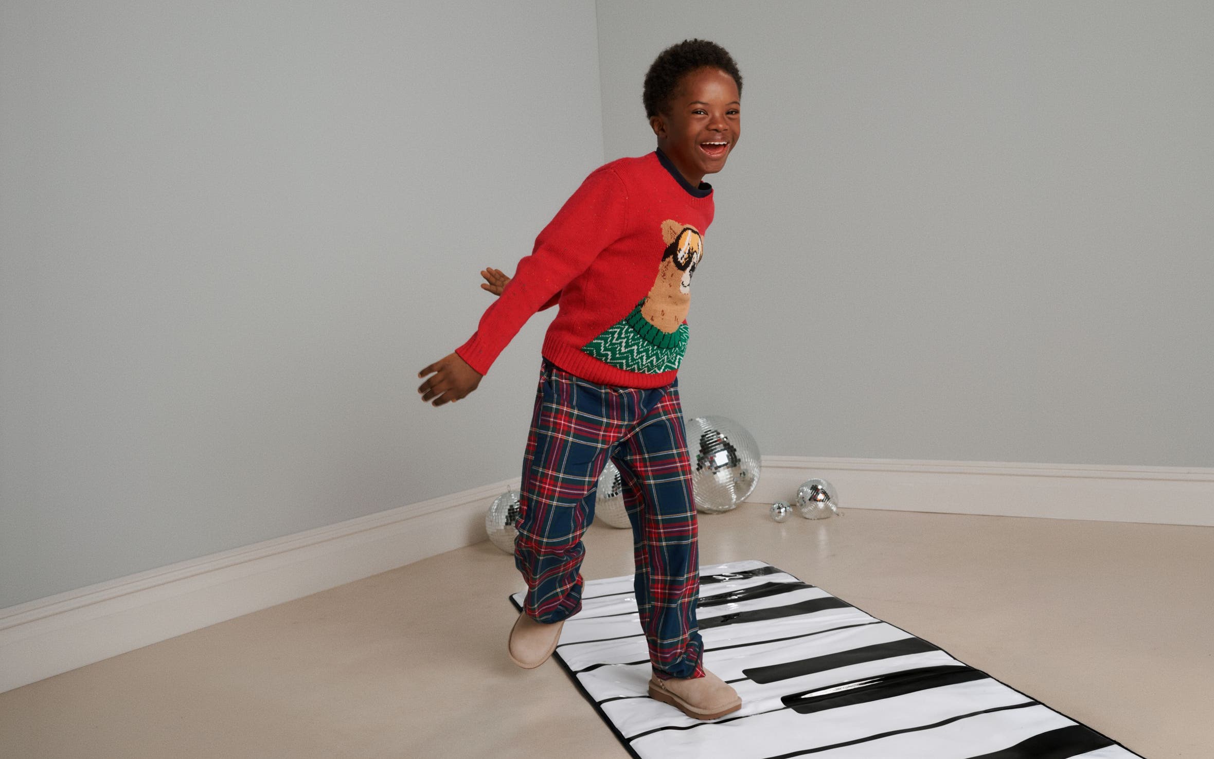 A boy playing on a piano floor mat.