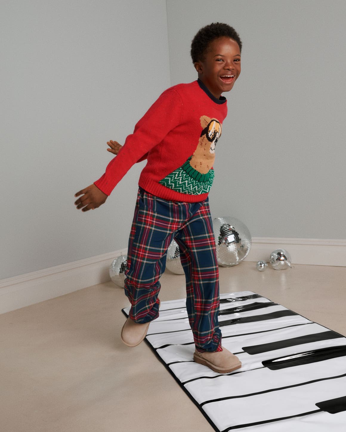 A boy playing on a piano floor mat.